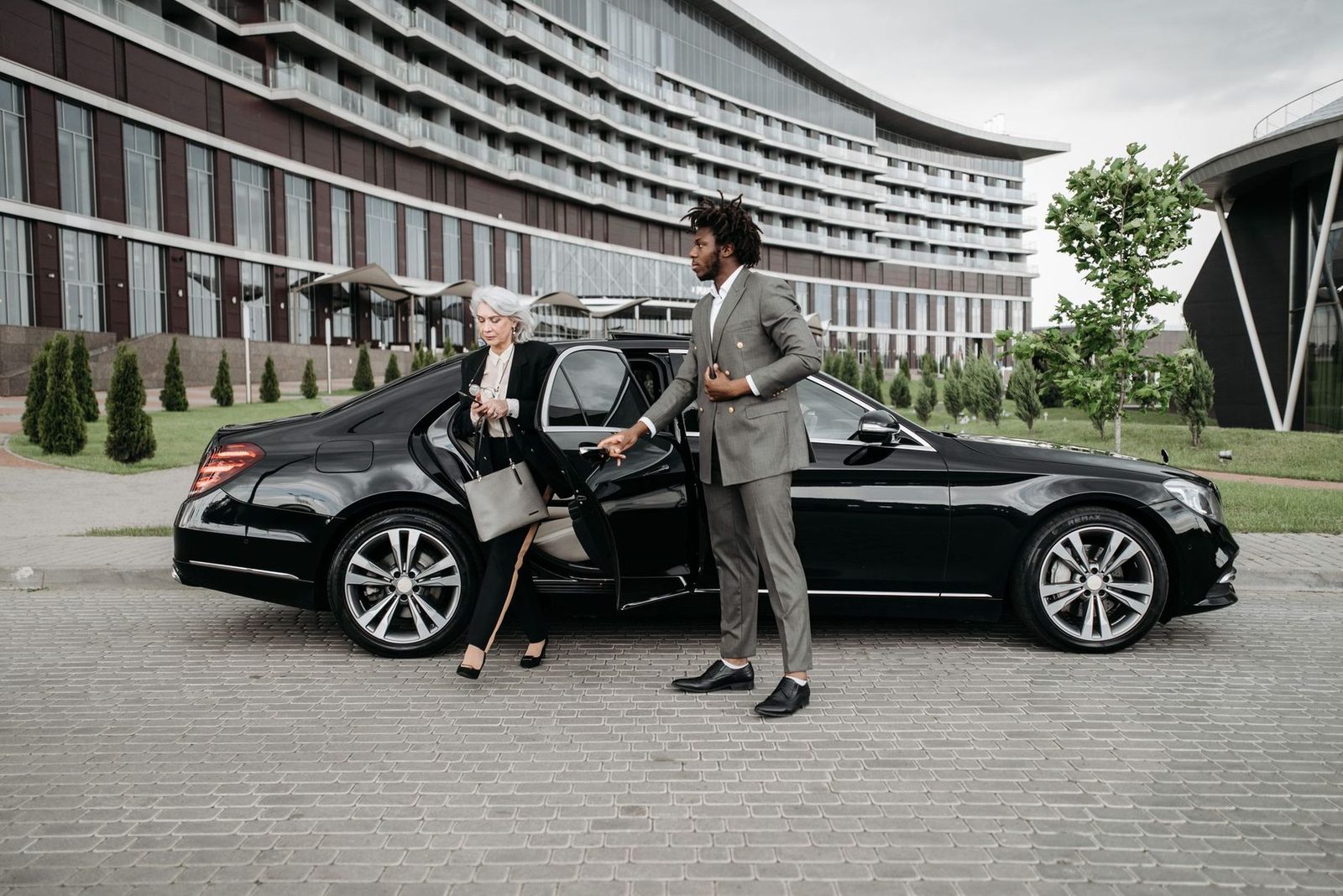 Chauffeur opening the door of a black executive sedan for a client in Toronto
